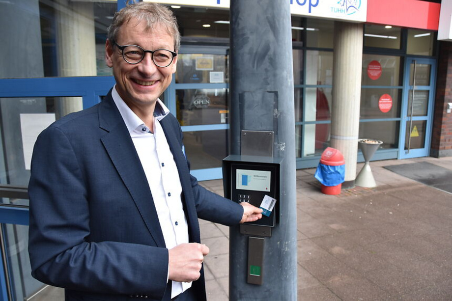TU-Präsident Andreas Timm-Giel probiert den neuen Bibliotheksausweis für die Open Library aus.