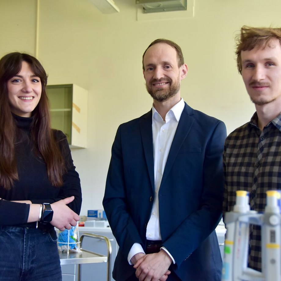 Drei Personen stehen nebeneinander in einem Labor und blicken in die Kamera: Dr. Alexandra Tsouka, Prof. Felix Löffler und Dr. Ondrej Havelka.