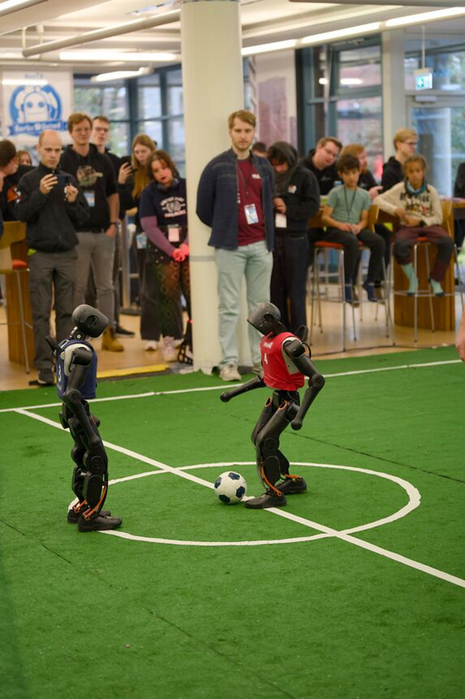 Zwei Roboter spielen Fußball.