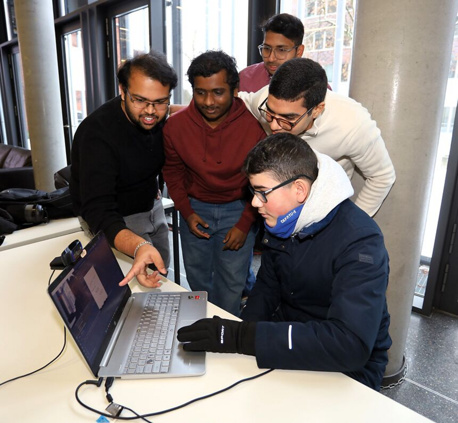 students standing around a laptop