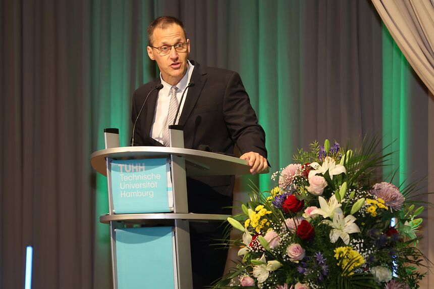ein Mann am Rednerpult spricht in das Mikrofon