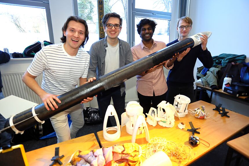four students holding a self-made rocket