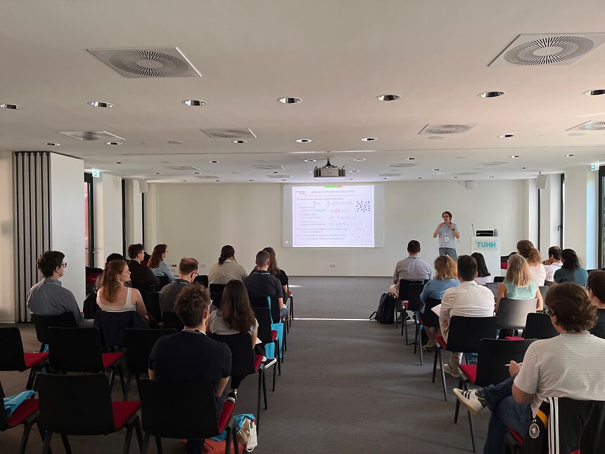 ein Konferenzraum mit Publikum, das in Stuhlreihen sitzt