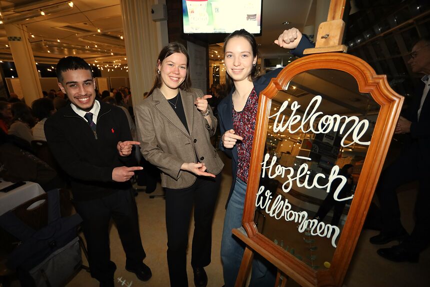 young people pointing to a sign